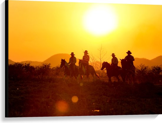 Canvas - Groepje Cowboys op Paarden Rijdend door Landschap bij de Ondergaande Zon - 100x75 cm Foto op Canvas Schilderij (Wanddecoratie op Canvas)