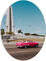 WallClassics - PVC Schuimplaat Ovaal - Roze Auto bij Gebouw in Cuba - 42x56 cm Foto op Ovaal (Met Ophangsysteem)