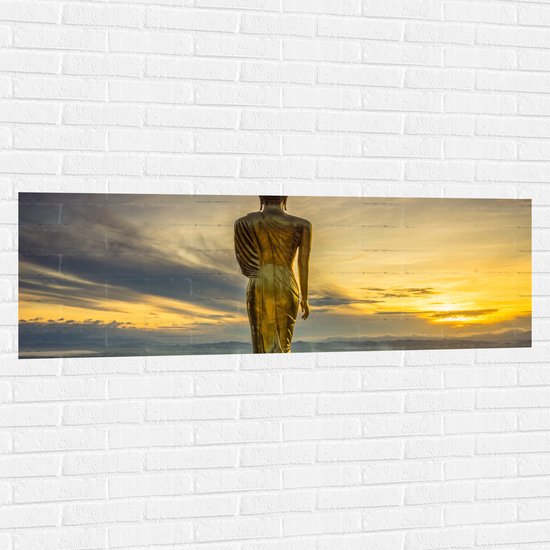 Muursticker - Gouden Buddha op Standaard met Uitzicht op Landschap - 150x50 cm Foto op Muursticker