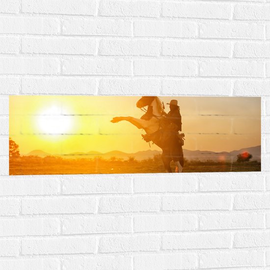 Muursticker - Felle Grote Zon achter Stijgerend Paard met Cowboy - 90x30 cm Foto op Muursticker