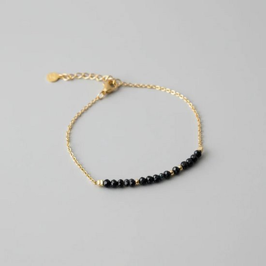 Gouden armband met een rij kleine, zwarte toermalijn kraaltjes en een verlengkettinkje.