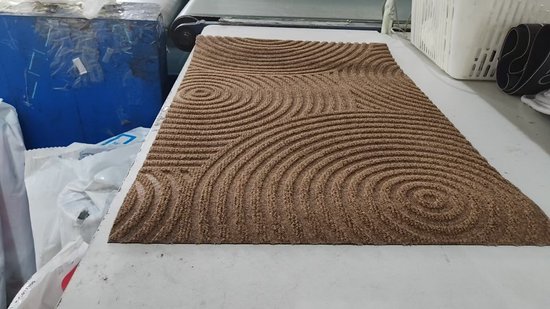 Bruine deurmat met een cirkelvormig lijnenpatroon.