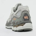Achterkant van de grijze ASICS Gel-NYC sneaker met oranje 'GEL' en ASICS logo's.