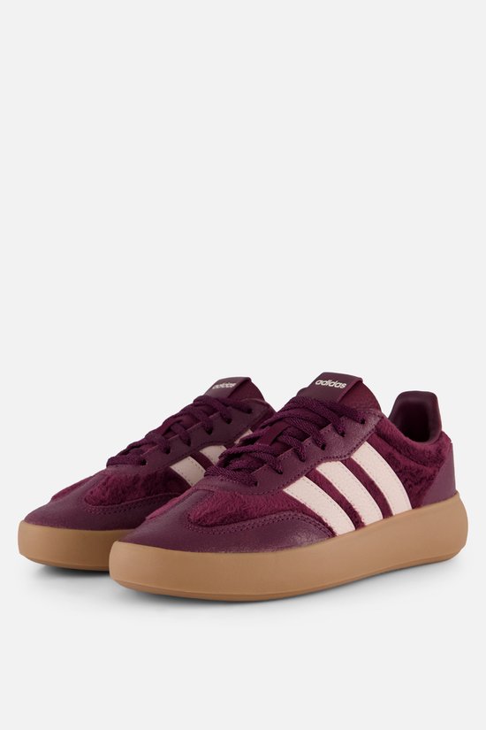 Paar bordeauxrode Adidas sneakers met crèmekleurige strepen en bruine zolen, gezien vanaf de voorkant.