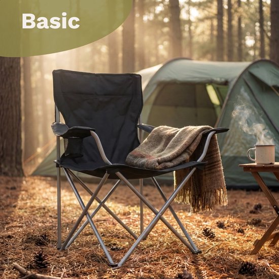 Zwarte opvouwbare campingstoel met een plaid en mok koffie op een camping.