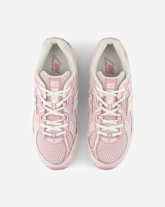 Roze New Balance sneakers met witte veters en crèmekleurige zolen.