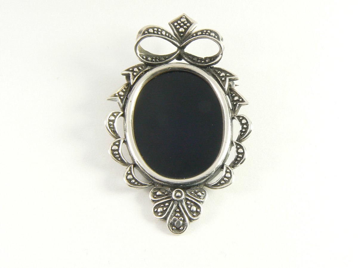 Bewerkte zilveren broche met onyx