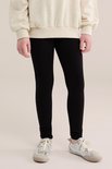 Gedetailleerde weergave van zwarte legging met sneakers.