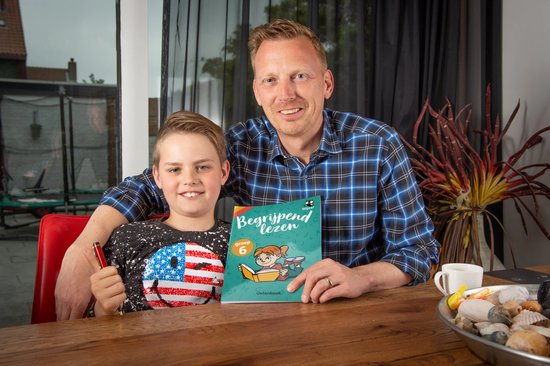 Man met blauw-zwart geruit shirt en jongen met t-shirt met Amerikaanse vlag. Ze houden een boek 'Begrijpend lezen groep 6' vast.