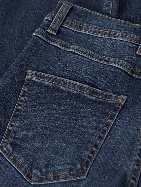Detail van de achterkant van een donkerblauwe spijkerbroek, met zicht op de zakken en stiksels.