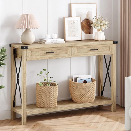 Lichtbruine console tafel met rieten lades, twee manden en decoraties. Zwart X-vormig frame.