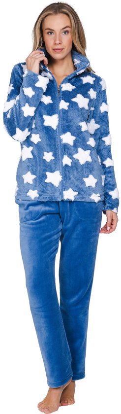 Vrouw in blauw fleece pyjamapak met witte sterrenprint en rits, staand op witte achtergrond.