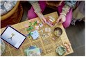 Mains d'enfant construisant des fleurs LEGO et une tablette avec des instructions, à côté d'un flacon et d'un bol de perles.