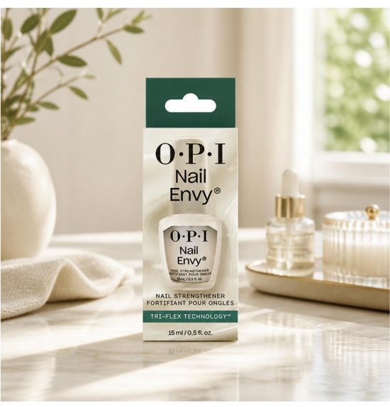 O.P.I. Nail Envy nagelverharder flesje en verpakking, met een gedrapeerde plant en een decoratieve kaars op de achtergrond.