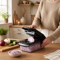 Een vrouw snijdt een rode ui in blokjes met de Lekro groentesnijder in een lichte keuken.
