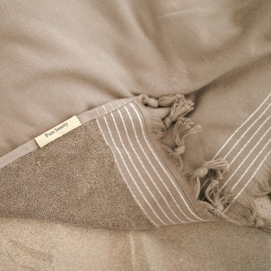 Bruine hamamdoek met witte strepen, franjes en 'Pure beauty' label.