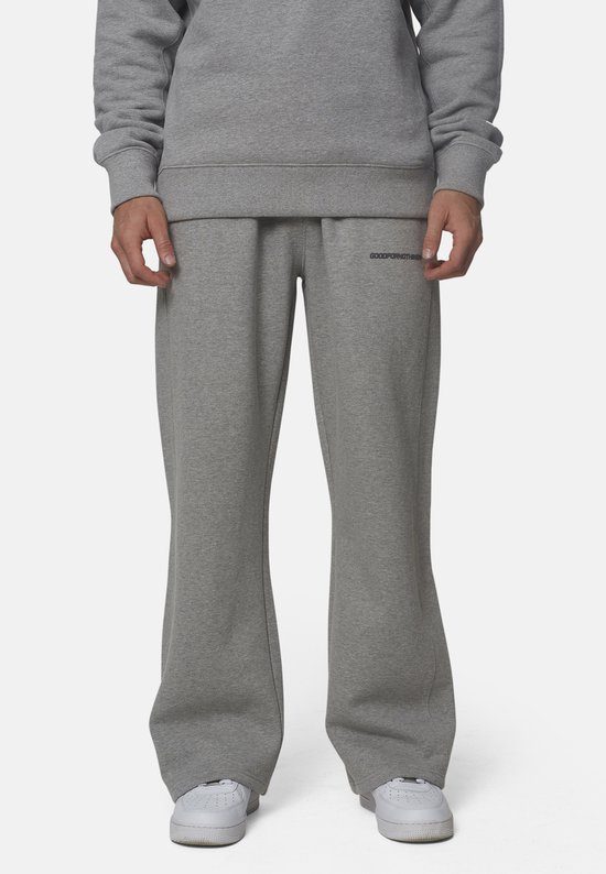 Man draagt een grijze joggingbroek met logo op de linkerpijp.