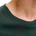 Detail van de ronde hals van een donkergroen T-shirt met stiksels.