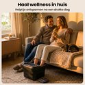 Koppel ontspant op een bank met het voetenbad, een kat slaapt op een deken.