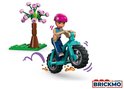 Een LEGO Friends minipop met roze helm op een turquoise motor, met een boom op de achtergrond.