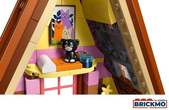 Interieur LEGO Friends Glamping Cabin met een zwart katje, een foto van katten en een slaapbank.