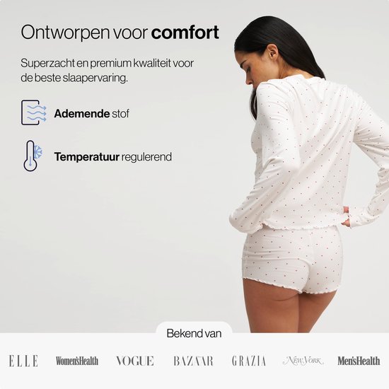 Model met witte pyjamaset met rode hartjes, lange mouwen en korte broek.
