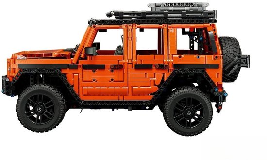 Zijprofiel van de oranje LEGO Technic Mercedes-Benz G 500 met dakrek en reservewiel.