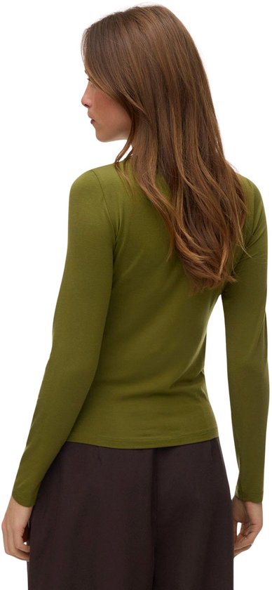 Model van achteren gezien in een groen shirt met lange mouwen en een bruine broek.