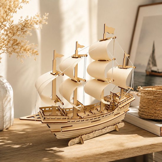Houten model van een zeilschip met beige zeilen, staande op een houten standaard. Zonnestralen vallen op het model.