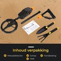 Zwarte metaaldetector met oranje accenten, inclusief schep, hark en handleiding, op zand.