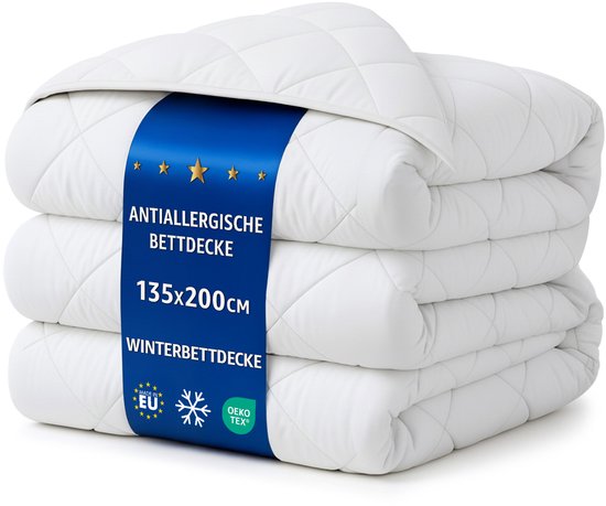 Gestapelde witte winterdekbedden met band met informatie over grootte en certificering.