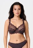 Model draagt een bruine LingaDore beugelbeha en slip met roze kanten bloemendetails.