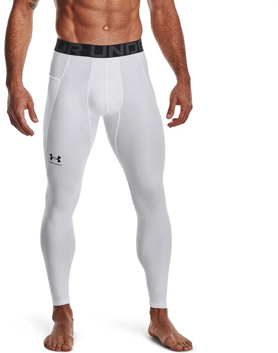 Man met witte Under Armour sportlegging, zwarte band met 'Under Armour' tekst, zwart UA logo op linkerbeen en zakjes aan de zijkant.