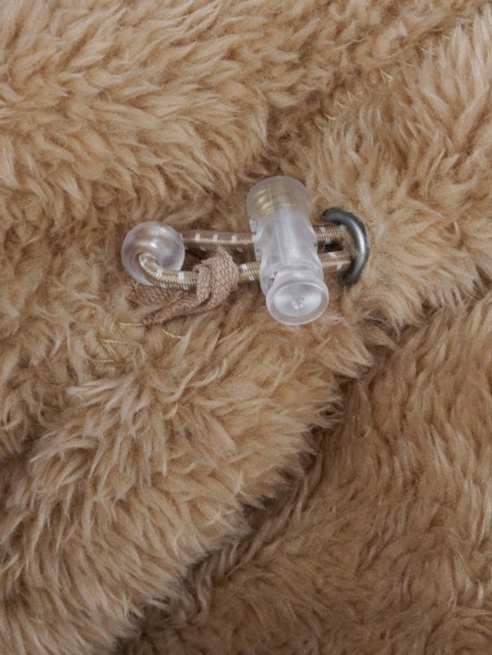 Detail van de sluiting met koord en knopen op een camelkleurig fleece vest.
