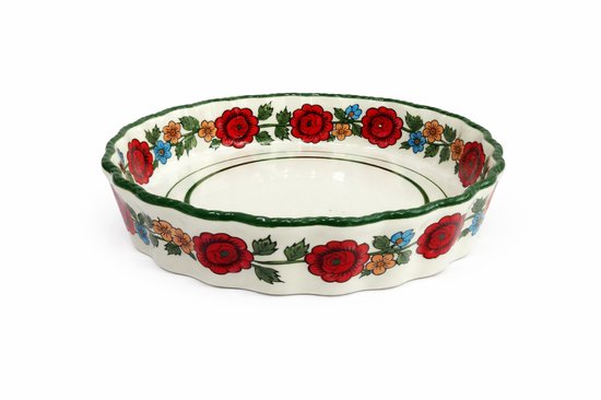 Ronde, witte keramische bakvorm met groen geribbelde rand, beschilderd met rode rozen, oranje en blauwe bloemen.