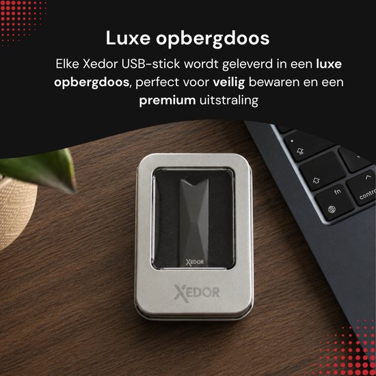 Grijze Xedor USB-stick in een luxe metalen bewaardoos, naast een laptop.