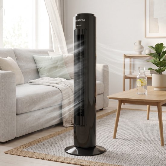 Zwarte HAUSBERG torenventilator van 75 cm blaast koele lucht, staand op een vloerkleed naast een bank.