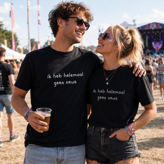 Een koppel in festivaloutfits met zwarte t-shirts waarop 'ik heb helemaal geen neus' staat.