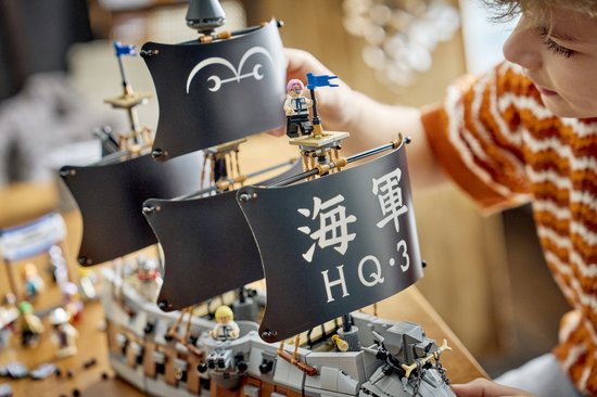 Kind bouwt aan de zwarte zeilen van de LEGO Garp's Marine Battleship.