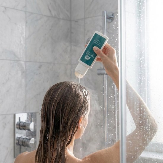 Vrouw in de douche die Zechsal magnesium hair & body wash in haar haar aanbrengt.