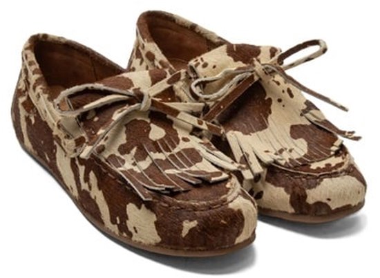 Lichtbruine en witte Lazamani mocassins met koeienprint en franjes aan de voorkant.