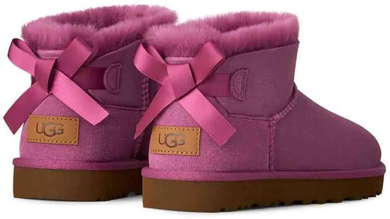 Paarse UGG laarsjes met roze strikken op de rug en bruine zolen.