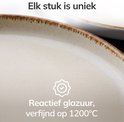 Close-up van beige serviesgoed met een reactief geglazuurde, verfijnde afwerking op 1200°C. Unieke, rustieke bruine rand.