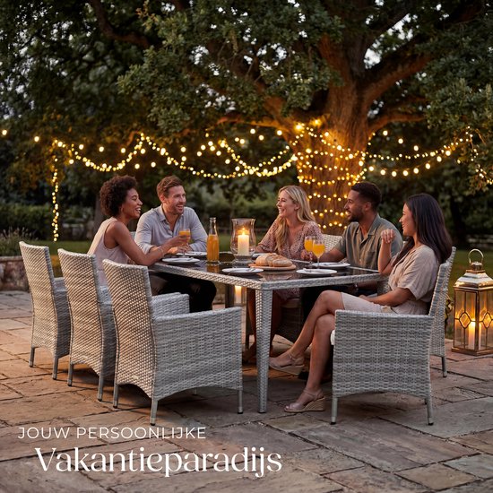 Grijze wicker tuinset met tafel en stoelen, met mensen dineren buiten bij avond, met lighjes.