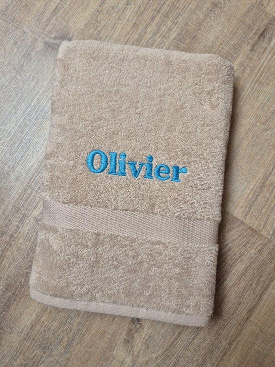 Serviette de bain couleur crème avec le prénom 'Olivier' brodé en bleu vif.