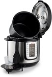 Zilverkleurige Tefal multicooker met open deksel, toebehoren zoals een maatbeker en spatel ernaast.