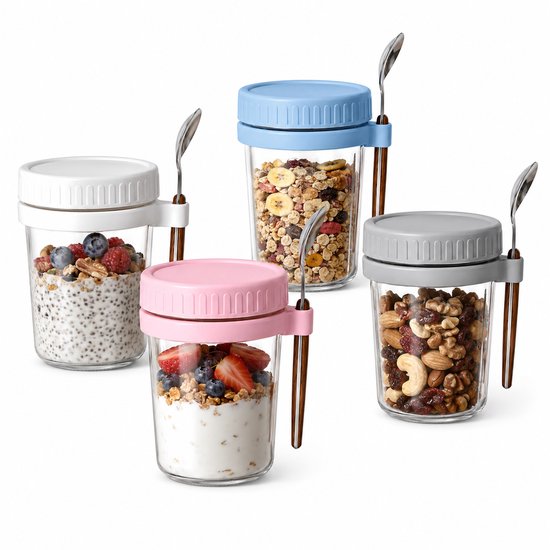 Vier gevulde glazen potjes met lepel. Yoghurt met fruit, muesli, noten en chia pudding.