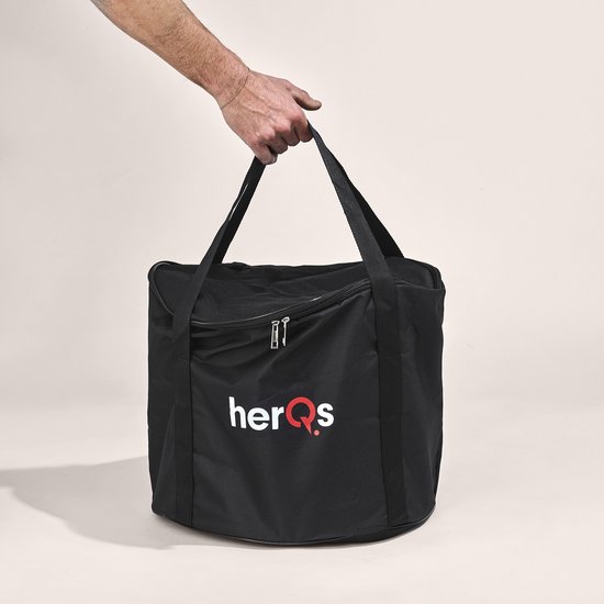 Hand draagt een zwarte HerQs draagtas met een zilverkleurige vuurkorf erin