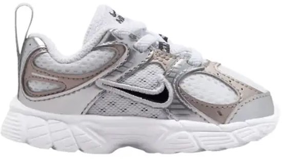Witte sneaker met zilverkleurige panelen, zilverkleurige hielaccenten, een zwarte Nike swoosh en vetersluiting.