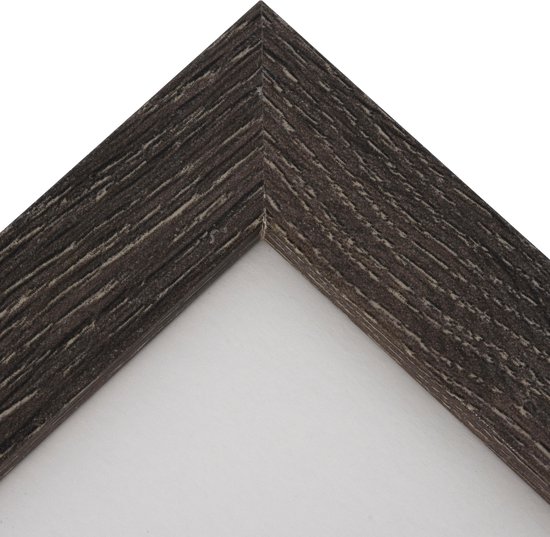 Détail du coin d'un cadre photo gris foncé avec un motif de bois vieilli.